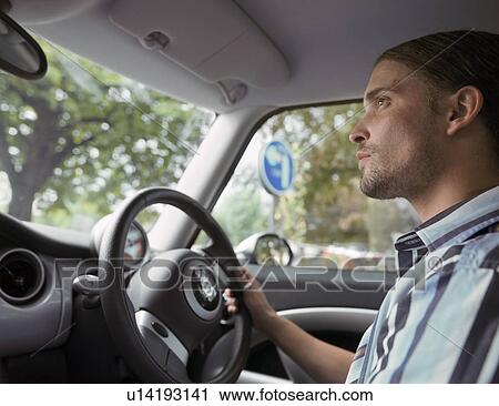 Stock Image - Close up of man driving a car. Fotosearch