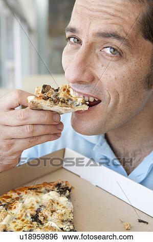Close up of man eating pizza View Large Photo Image Stock Photograph - Close up of man eating pizza. Fotosearch
