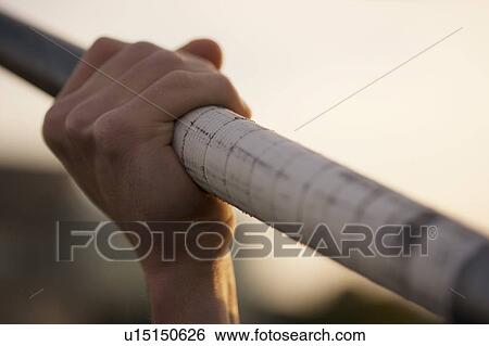 Stock Photograph - Close up of man holding pole. Fotosearch
