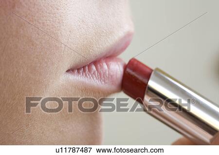 Close up of woman applying lipstick View Large Photo Image Stock Photo - Close up of woman applying lipstick. Fotosearch