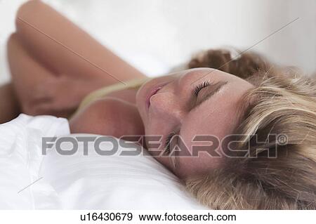 Stock Photo - Close up of woman asleep in bed. Fotosearch