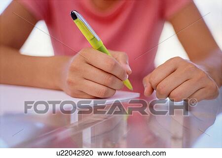 Stock Image - Close up of woman writing. Fotosearch
