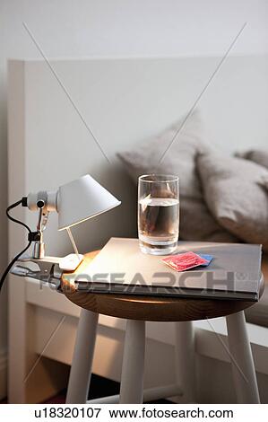 Condoms and water on bedside table View Large Photo Image Stock Photo - Condoms and water on bedside table. Fotosearch