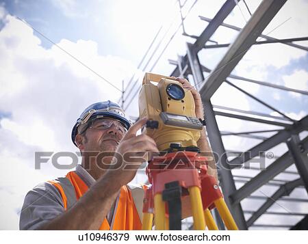 Construction worker surveying site View Large Photo Image Stock Photo - Construction worker surveying site. Fotosearch