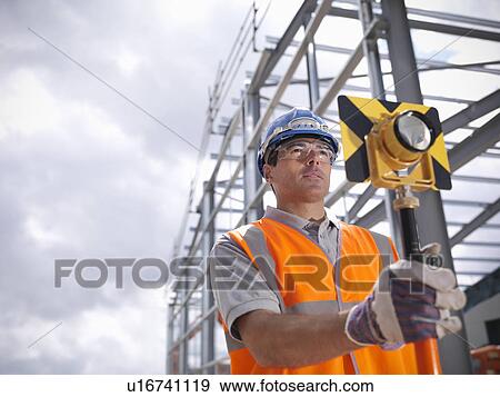 Construction worker surveying site View Large Photo Image Stock Photo - Construction worker surveying site. Fotosearch