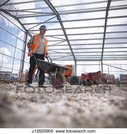 Stock Photography - Construction worker with wheelbarrow. Fotosearch