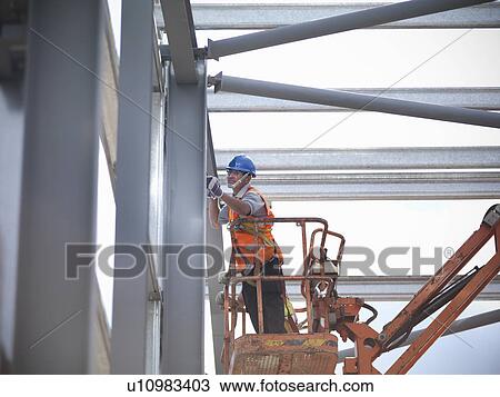 Stock Image - Construction workers in cherry picker. Fotosearch