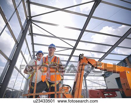 Stock Image - Construction workers in cherry picker. Fotosearch