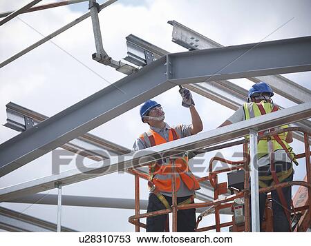 Stock Image - Construction workers in cherry picker. Fotosearch