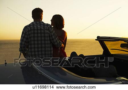 Picture - Couple admiring view on convertible. Fotosearch