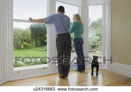 Couple and dog admiring new home View Large Photo Image Stock Image - Couple and dog admiring new home. Fotosearch