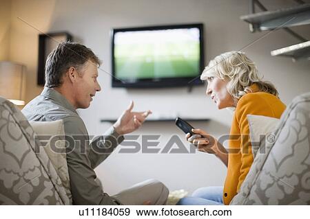 Couple arguing over remote control View Large Photo Image Stock Photo - Couple arguing over remote control. Fotosearch