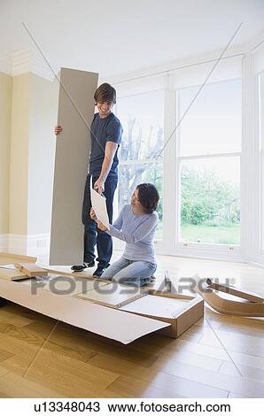 Couple building furniture in new home View Large Photo Image Stock Image - Couple building furniture in new home. Fotosearch