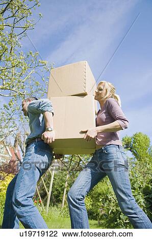 Stock Image - Couple carrying cardboard boxes. Fotosearch