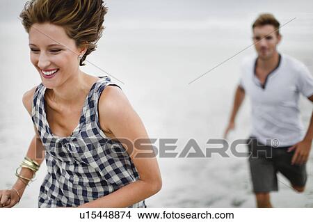 Couple chasing each other on beach View Large Photo Image Picture - Couple chasing each other on beach. Fotosearch