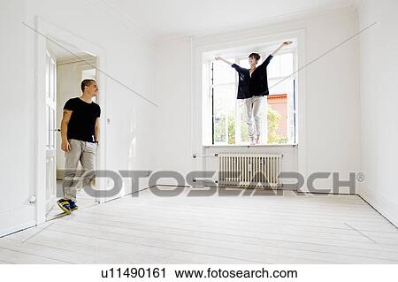 Couple cheering in new home View Large Photo Image Stock Image - Couple cheering in new home. Fotosearch
