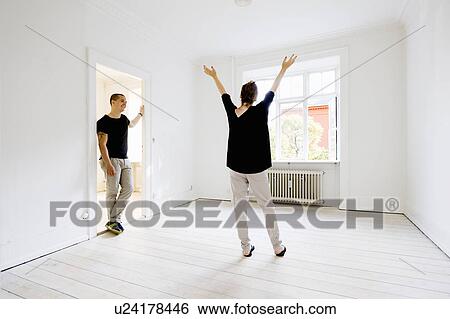 Stock Photograph - Couple cheering in new home. Fotosearch