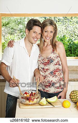 Couple cooking together in kitchen View Large Photo Image Stock Image - Couple cooking together in kitchen. Fotosearch