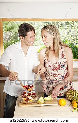 Couple cooking together in kitchen View Large Photo Image Stock Photography - Couple cooking together in kitchen. Fotosearch