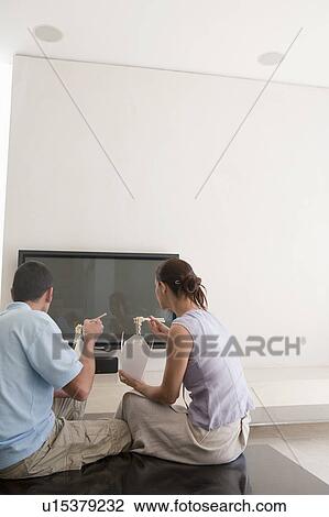 Stock Image - Couple eating Chinese take out. Fotosearch