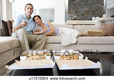Couple eating pizza in living room View Large Photo Image Picture - Couple eating pizza in living room. Fotosearch