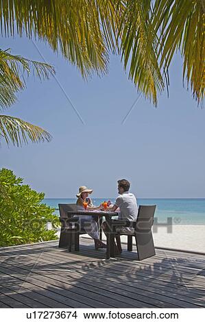Couple eating together on deck at beach View Large Photo Image Picture - Couple eating together on deck at beach. Fotosearch