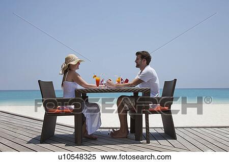 Couple eating together on deck at beach View Large Photo Image Stock Photography - Couple eating together on deck at beach. Fotosearch