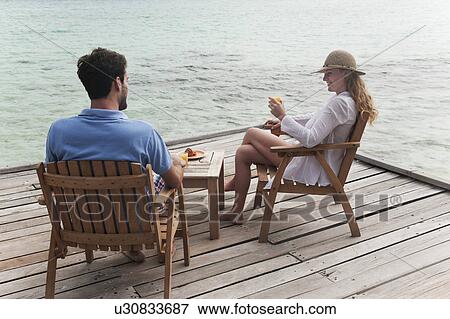 Couple eating together on deck View Large Photo Image Stock Photo - Couple eating together on deck. Fotosearch