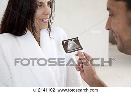 Stock Image - Couple examining sonogram together. Fotosearch
