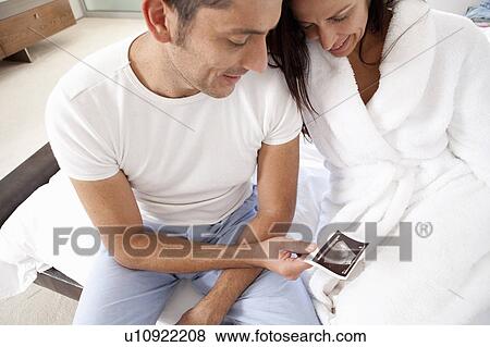 Stock Photo - Couple examining sonogram together. Fotosearch