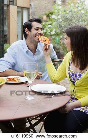 Couple feeding each other pizza outdoors View Large Photo Image Stock Image - Couple feeding each other pizza outdoors. Fotosearch