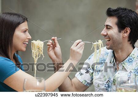 Stock Photography - Couple feeding each other spaghetti. Fotosearch