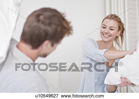 Couple having a pillow fight in bedroom View Large Photo Image Stock Photo - Couple having a pillow fight in bedroom. Fotosearch
