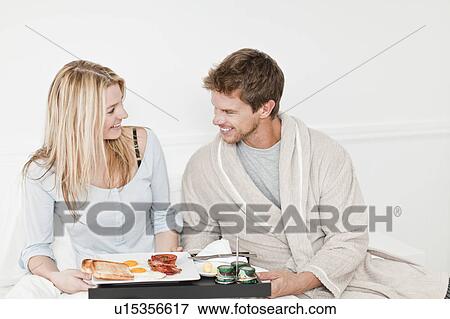 Couple having breakfast in bed View Large Photo Image Stock Photo - Couple having breakfast in bed. Fotosearch