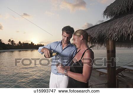 Couple having champagne on dock View Large Photo Image Stock Photo - Couple having champagne on dock. Fotosearch