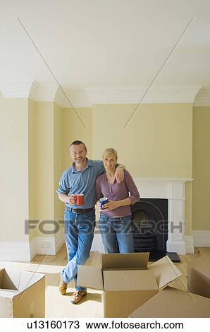Stock Image - Couple having coffee in new home. Fotosearch