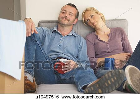 Stock Photograph - Couple having coffee on sofa together. Fotosearch