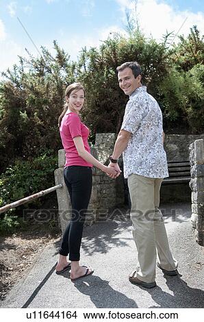 Picture - Couple holding hands in courtyard. Fotosearch
