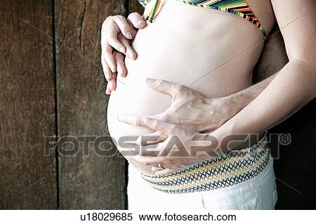 Couple holding woman's pregnant belly View Large Photo Image Stock Photography - Couple holding woman's pregnant belly. Fotosearch