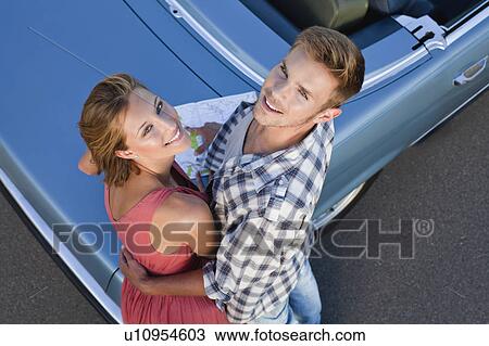 Couple hugging by convertible View Large Photo Image Stock Image - Couple hugging by convertible. Fotosearch