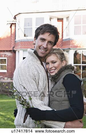 Picture - Couple hugging in backyard. Fotosearch
