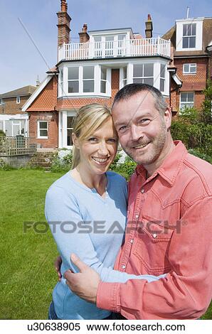 Stock Photography - Couple hugging in backyard. Fotosearch