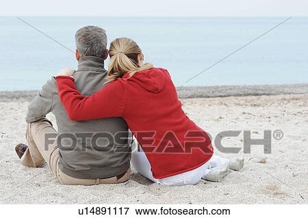 Couple hugging in sand on beach View Large Photo Image Stock Photo - Couple hugging in sand on beach. Fotosearch