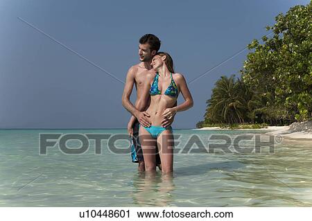 Couple hugging in water on beach View Large Photo Image Stock Image - Couple hugging in water on beach. Fotosearch