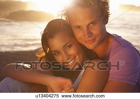 Couple hugging on beach at sunset View Large Photo Image Stock Photography - Couple hugging on beach at sunset. Fotosearch