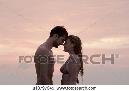 Couple hugging on beach at sunset View Large Photo Image Stock Photography - Couple hugging on beach at sunset. Fotosearch