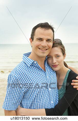 Stock Image - Couple hugging on beach. Fotosearch