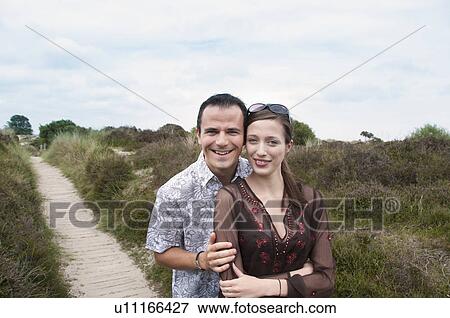 Couple hugging on beach walkway View Large Photo Image Stock Photo - Couple hugging on beach walkway. Fotosearch