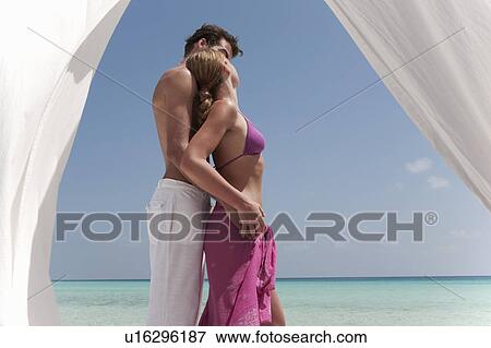 Stock Photo - Couple hugging on tropical beach. Fotosearch
