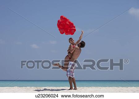 Couple hugging with balloons on beach View Large Photo Image Picture - Couple hugging with balloons on beach. Fotosearch